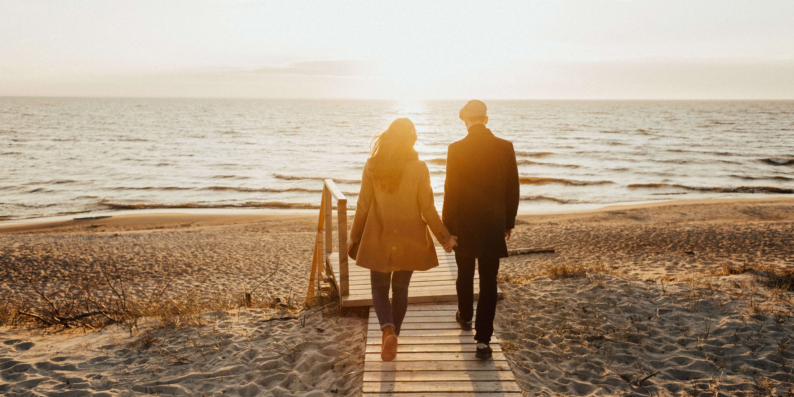 Couple holding hand and walking in a beach